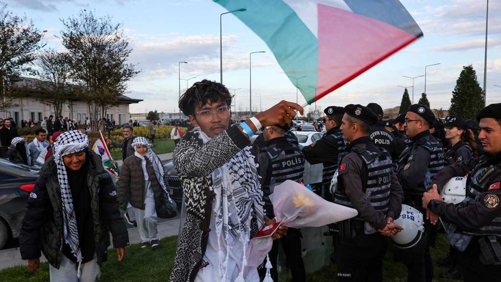 সুমুদ ফ্লোটিলায় অংশ নেওয়া এক মালয়েশীয় আন্দোলনকারী বিশেষ ফ্লাইটে ইস্তাম্বুল বিমানবন্দরে পৌঁছানোর পর ফিলিস্তিনের পতাকা প্রদর্শন করছেন। ছবি: রয়টার্স 