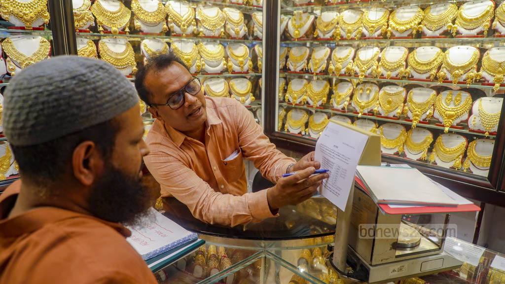 সোনার গহনা কিনতে এসে দাম শুনে হিমশিম খাচ্ছেন ক্রেতারা। তাদের বর্তমান মূল্যে তালিকা দেখাচ্ছেন বায়তুল মোকারম মার্কেটের এক দোকানি।  ছবি: আব্দুল্লাহ আল মমীন