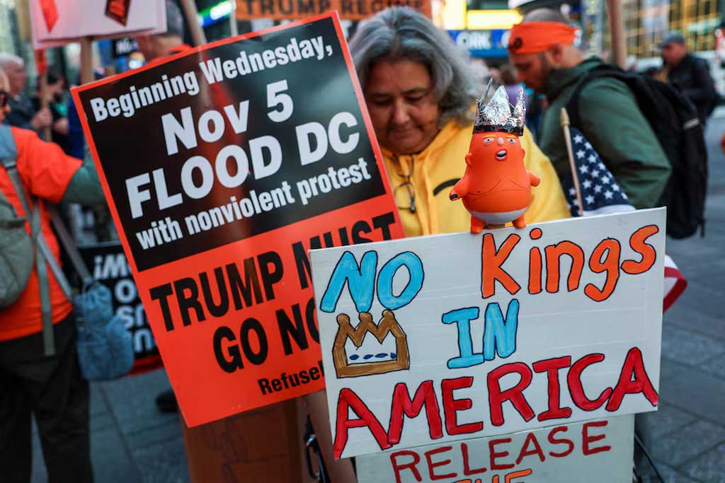 নিউ ইয়র্কের টাইমস স্কয়ারের বিক্ষোভে প্ল্যাকার্ড হাতে এক নারী। ছবি: রয়টার্স