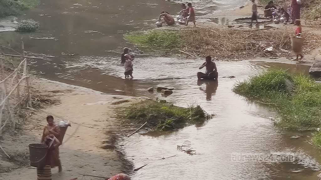 বান্দরবান সদরের সুয়ালক খালের পাশে এভাবে ছোট্ট গর্ত করে চারিদিকে বালু দিয়ে ঘিরে দেওয়া হয়। সামান্য খুঁড়লেই এসব গর্তে নিচ থেকে পানি উঠে আসে। পাহাড়ে এগুলো কুয়া হিসেবে পরিচিত। এমনই কুয়া থেকে পানি সংগ্রহে ব্যস্ত নারীরা। 
