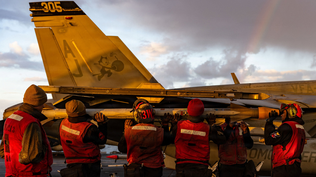 মার্কিন রণতরীতে যুদ্ধবিমানে বোমা ভরছেন যুক্তরাষ্ট্রের নৌবাহিনীর সদস্যরা। ছবি: রয়টার্স।