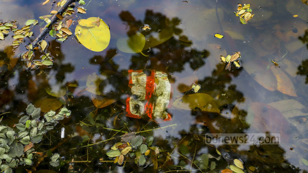 A plastic wrapper only sinks after soil or algae accumulates on it over a long period of time. The submerged wraps can be seen when the sun shines on the lake. 