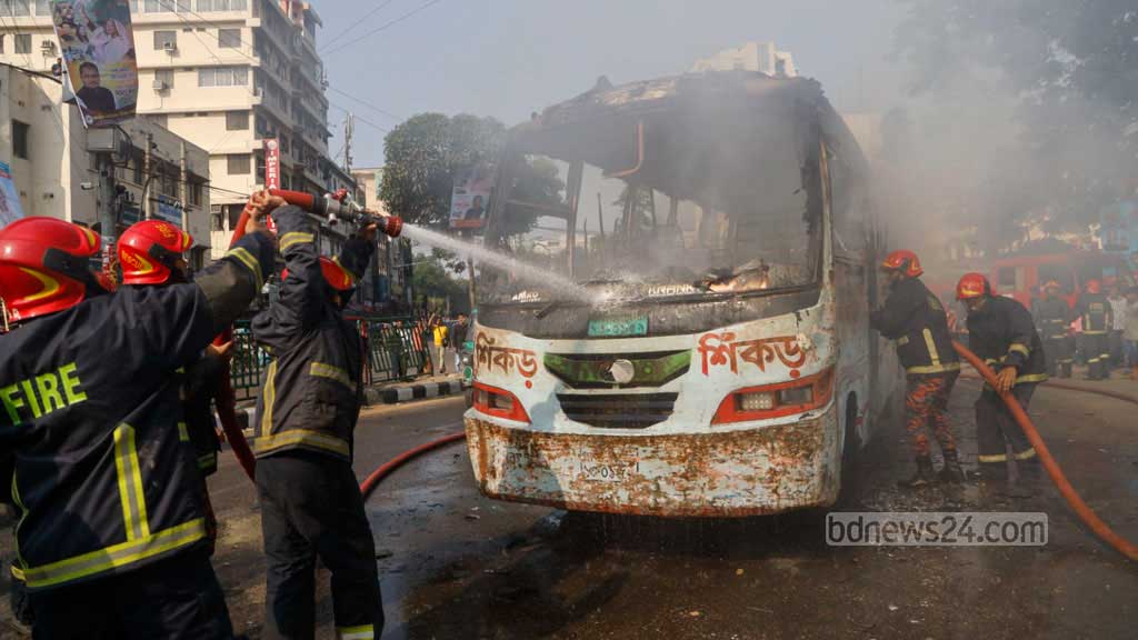 Fire service personnel attempt to extinguish a burning Shikor Paribahan bus after it was torched by strikers near the south gate of Baitul Mukarram National Mosque in Dhaka on Sunday amid a day-long shutdown called by the BNP, Oct 29, 2023. Photo: Mahmud Zaman Ovi