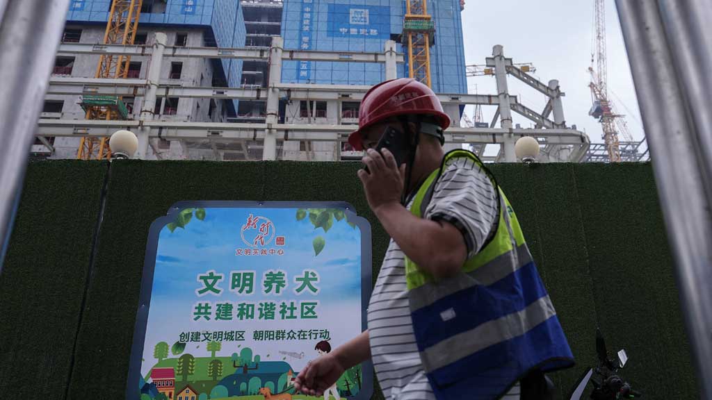 A worker walks past a construction site in Beijing's Central Business District (CBD), China Jul 14, 2024. REUTERS